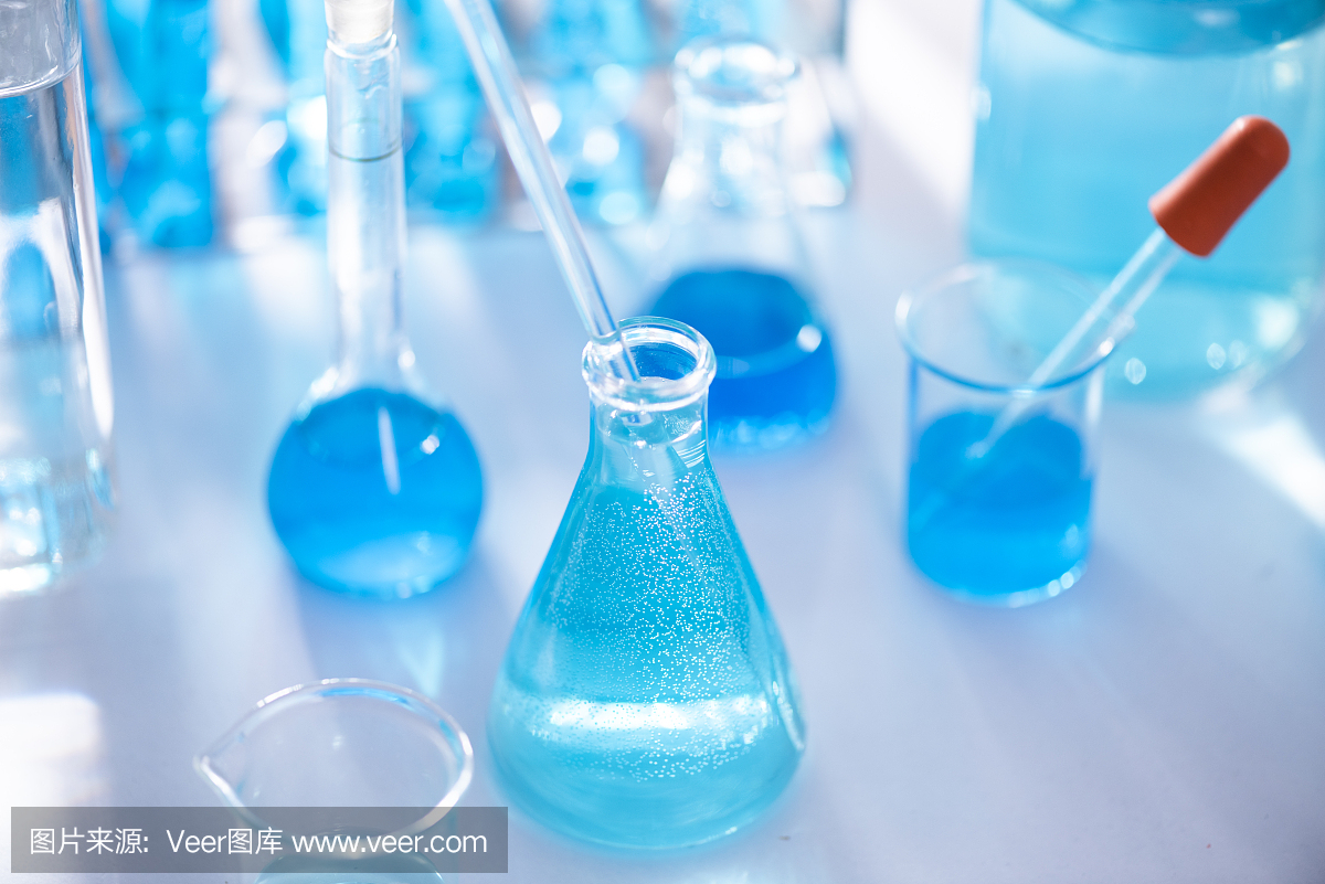 不同的实验室玻璃器皿,有彩色液体和反射